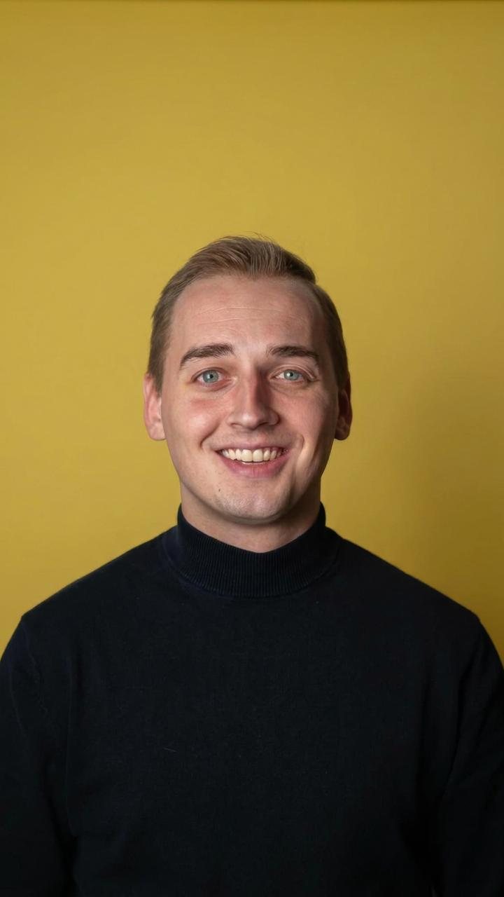 Portret van Romano Kanters voor een gele achtergrond